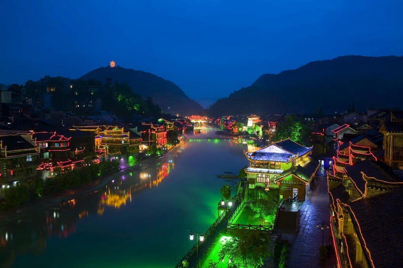 无人,家,宫殿,横图,俯视,彩色,室外,夜晚,旅游,度假,河流,名胜古迹,水,植物,标志建筑,地标,建筑,霓虹灯,夜景,中国,亚洲,阴影,遗迹,光线,凤凰,瓦片,影子,房屋,屋顶,屋檐,屋子,河水,水流,灯光,七彩,顶棚,古迹,文物,娱乐,光源,建设,古建筑,楼房,霓虹,檐,住宅,灯,树,树木,绿色,倒影,自然,享受,休闲,旅游胜地,放松,生长,成长,倒映,宫廷,照明设备,古文明,东亚,湖南,湘西,湖南省,凤凰古城,中华人民共和国,氖灯,华中地区,湘,湘西州,湘西土家族苗族自治州,王宫,反照,凤凰县,彩图,高角度拍摄,房子,皇宫,凤凰古城千潭苗寨,山江镇